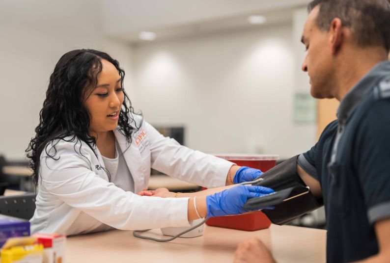 A student practices checking blood pressure